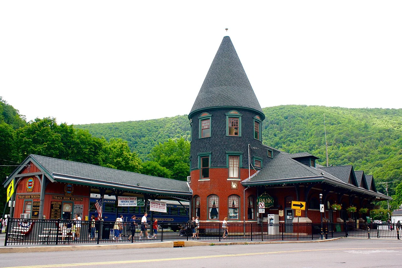 The historic Central Railroad of New Jersey Station in Jim Thorpe, with wooded hills behind it.