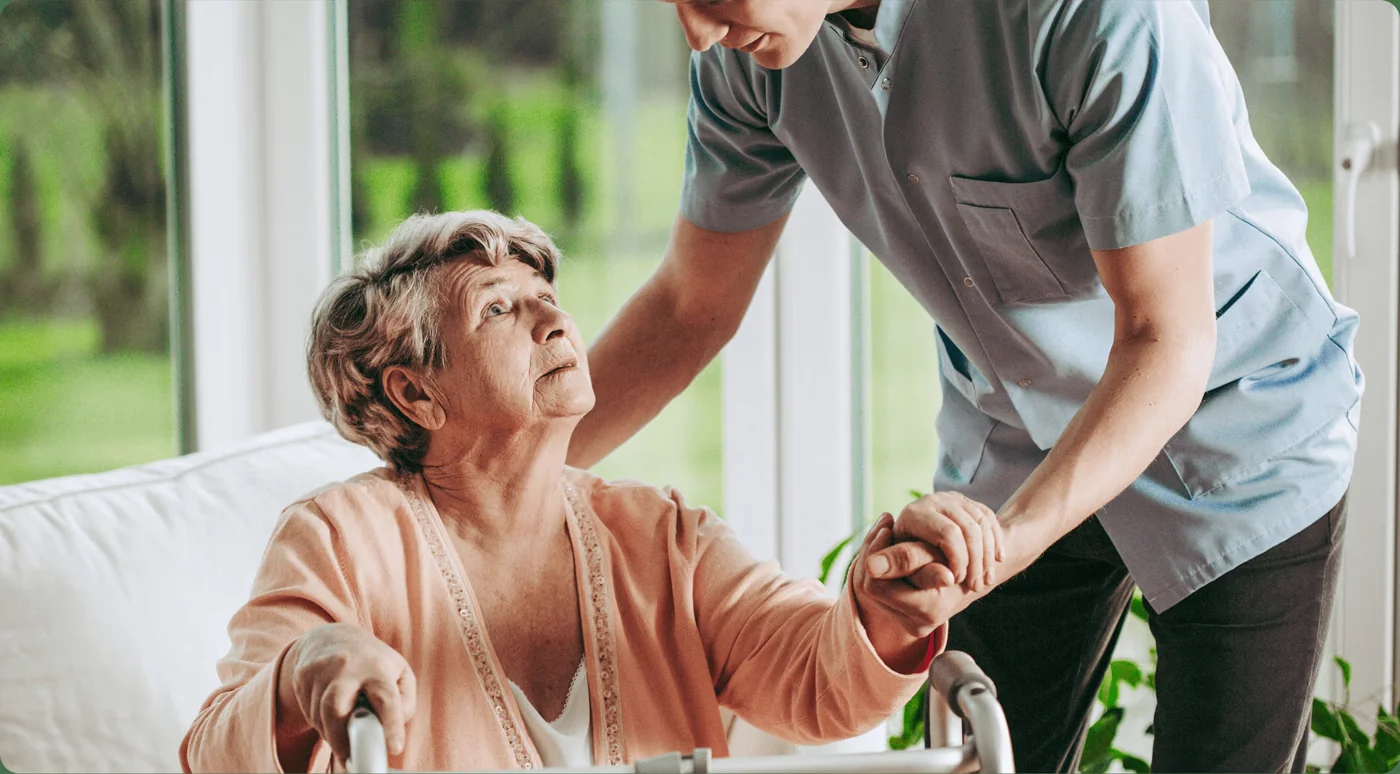 A care professional supporting an older woman at home