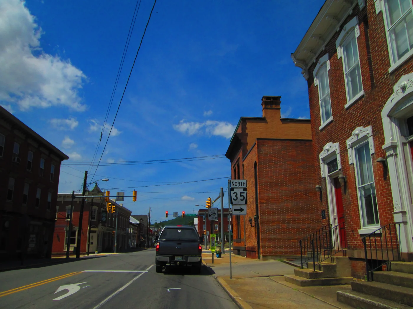 Historic brick buildings along Main Street in downtown Mifflintown beneath a blue summer sky.